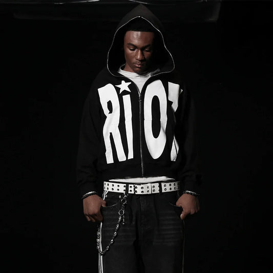 Person wearing a black hoodie with 'RIO' printed on it against a dark background