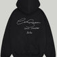 Back view of the Black Cole Buxton Oversized Hoodie, clearly showing the large, white signature script graphic with the Soho, London 2020 detail.