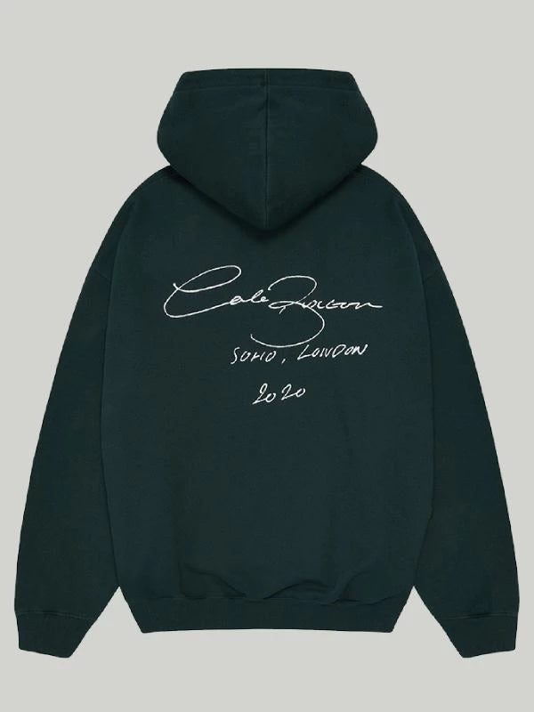 Back view of the premium Deep Forest Green Cole Buxton Oversized Hoodie, highlighting the large, crisp white signature script graphic with the Soho, London 2020 text.
