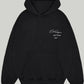 Front view of the Black Cole Buxton Oversized Hoodie, showcasing the white signature script logo on the chest and the large front pouch pocket.