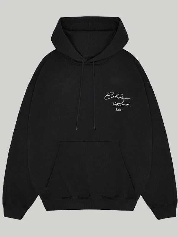 Front view of the Black Cole Buxton Oversized Hoodie, showcasing the white signature script logo on the chest and the large front pouch pocket.
