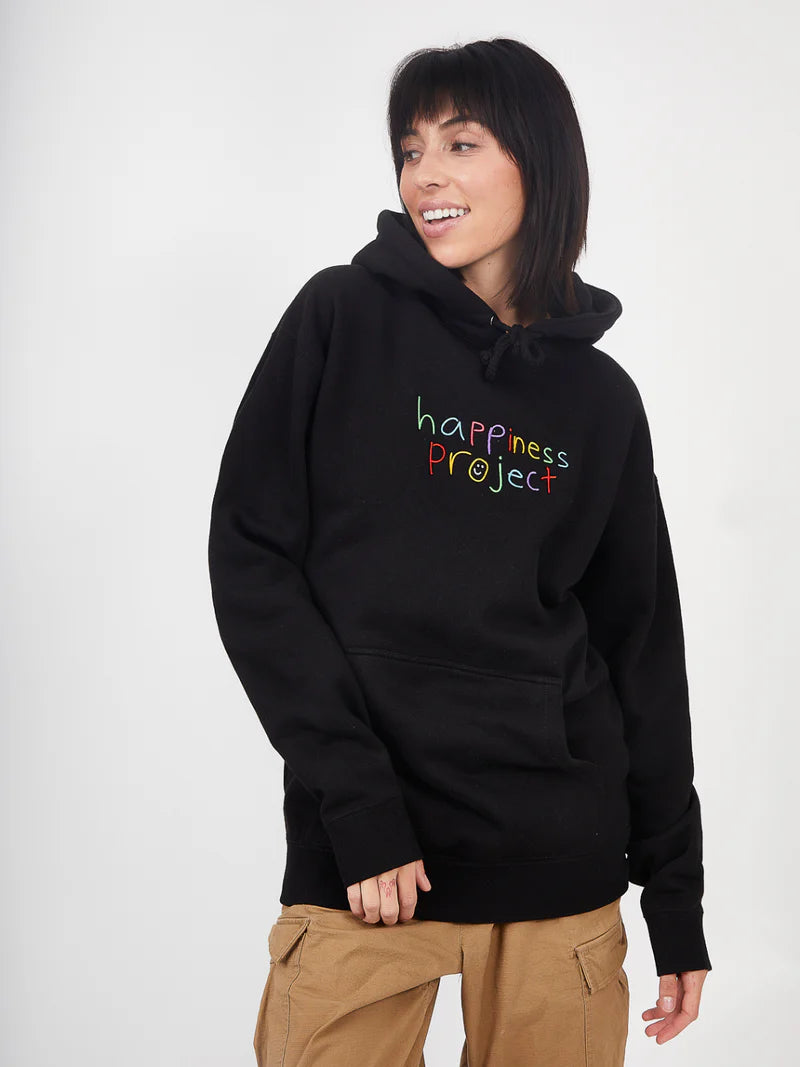 Person wearing a black hoodie with 'happiness project' text on a white background