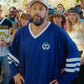 Man wearing a blue sports jersey with a logo, standing in front of a crowd.