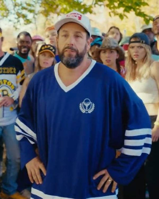 Man wearing a blue sports jersey with a logo, standing in front of a crowd.