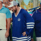 Man wearing a Happy Gilmore 2 Adam Sandler Blue Jersey jersey with white stripes in an outdoor setting