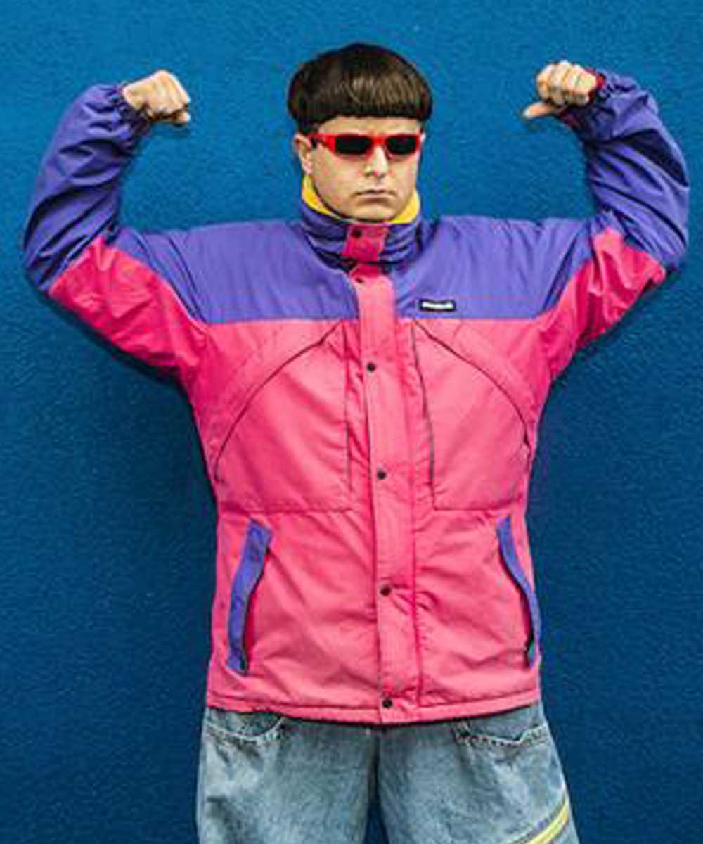 Person wearing a colorful jacket with a blue background