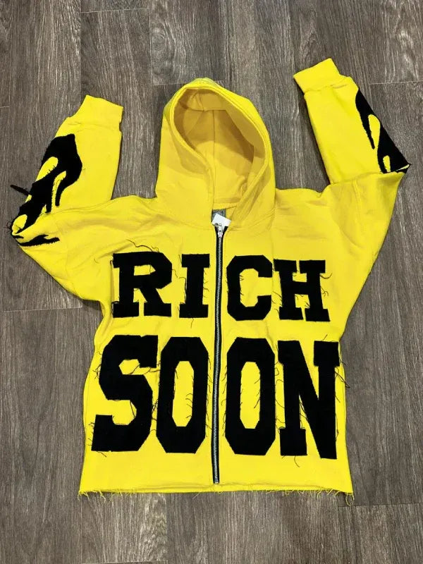 Front view of Yellow Rich-Soon-Zip-Up-Hoodie-Yellow with black flame graphics.