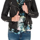 Person wearing a black leather jacket over a floral top and jeans on a white background