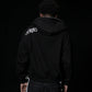 Person wearing a black hoodie with 'UNSTABLE' logo on the back against a dark background